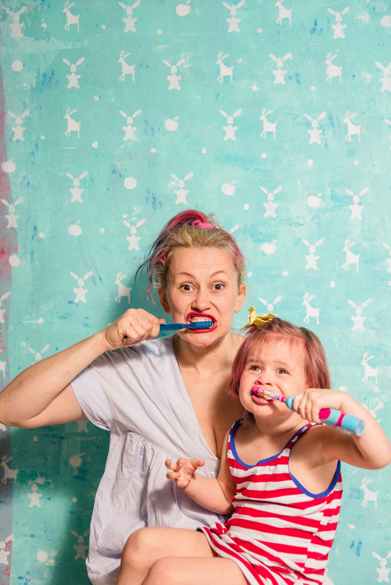 Mother and child brushing their teeth together