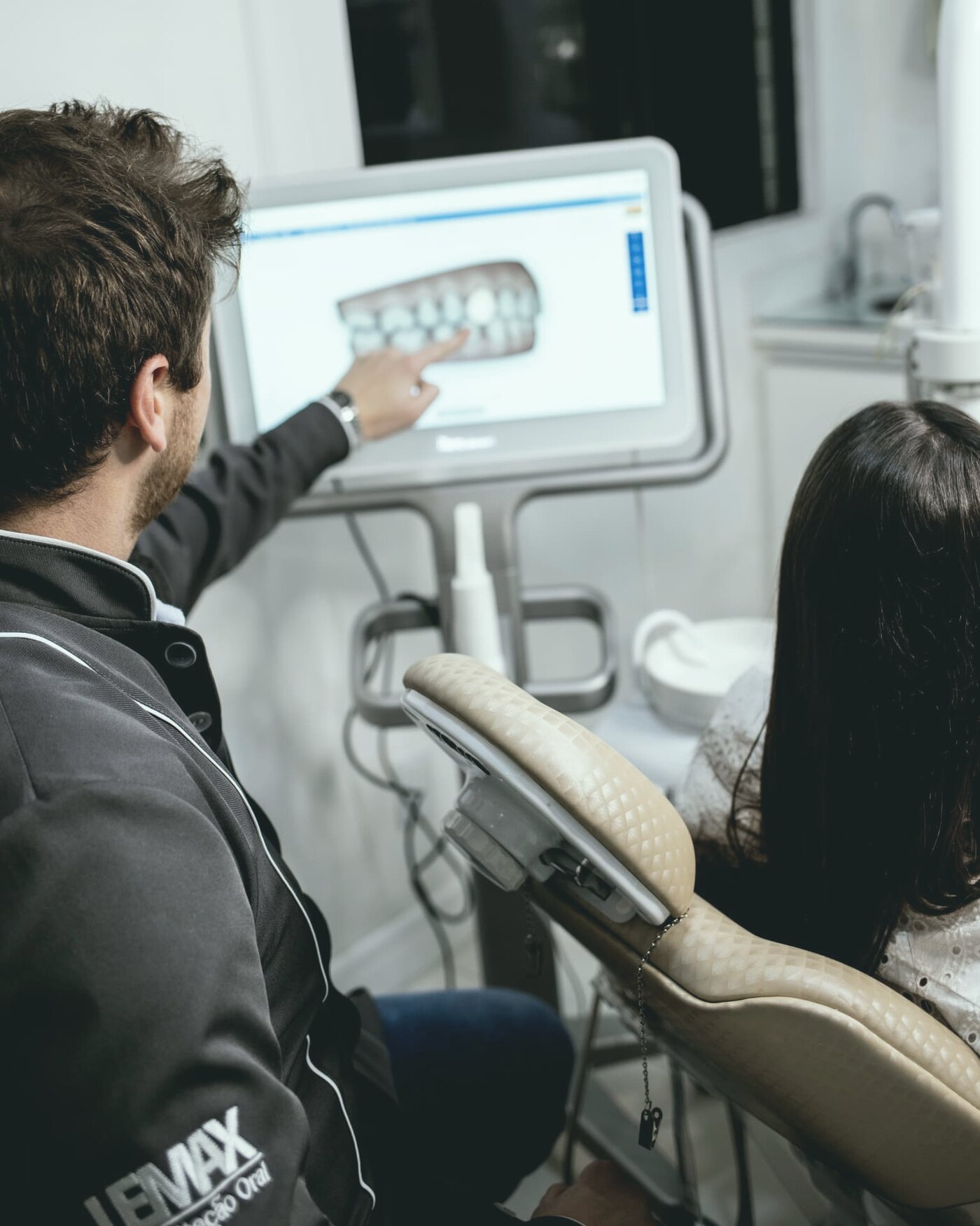 A dentist showing a patient her treatment plan on screen