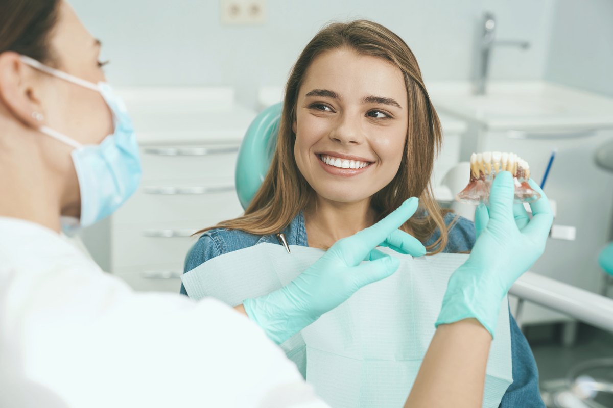 Patient smiling as a dentist explains a dental model